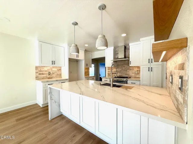 a view of large living room with kitchen view and a fireplace