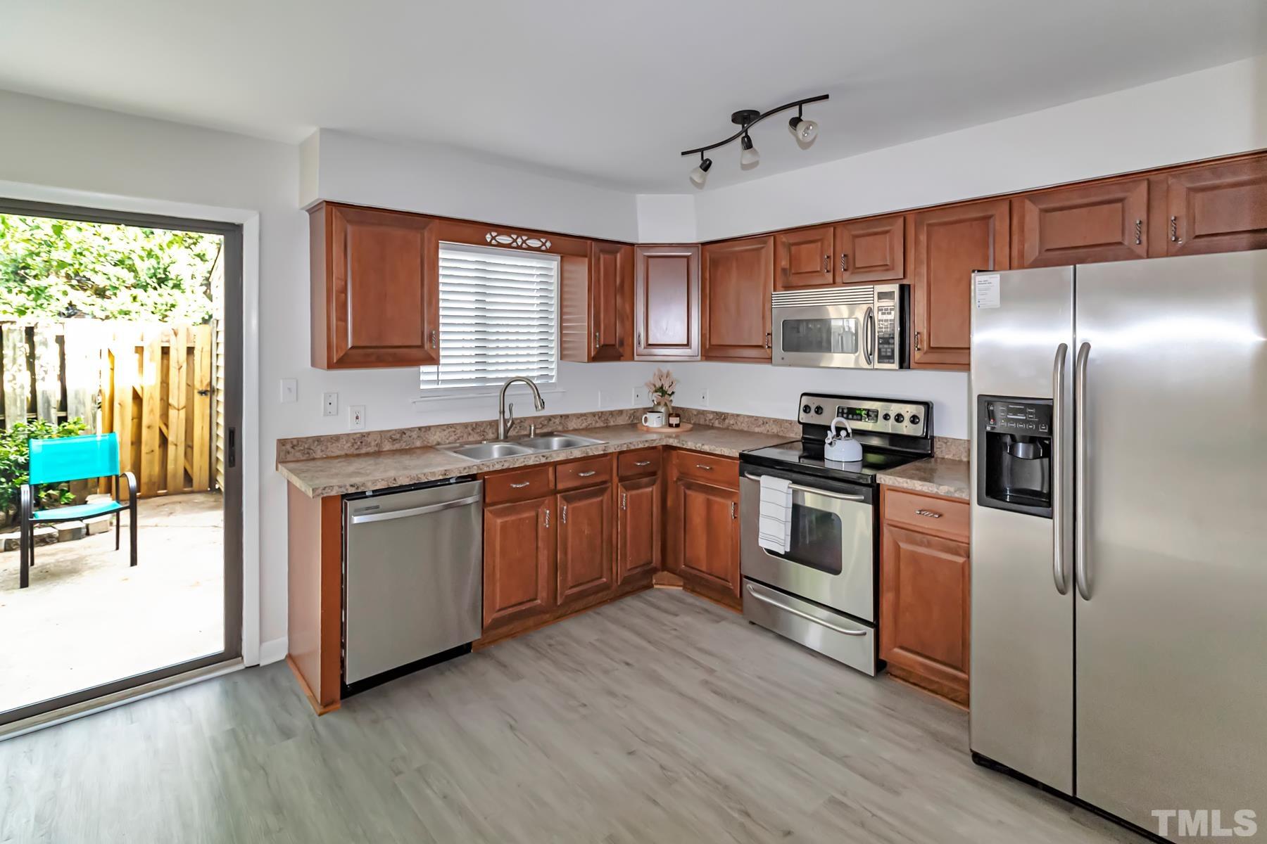 5840 Shady Grove Circle Raleigh, NC 27609 - Photo 5 of 18 a kitchen with granite countertop stainless steel appliances and wooden cabinets