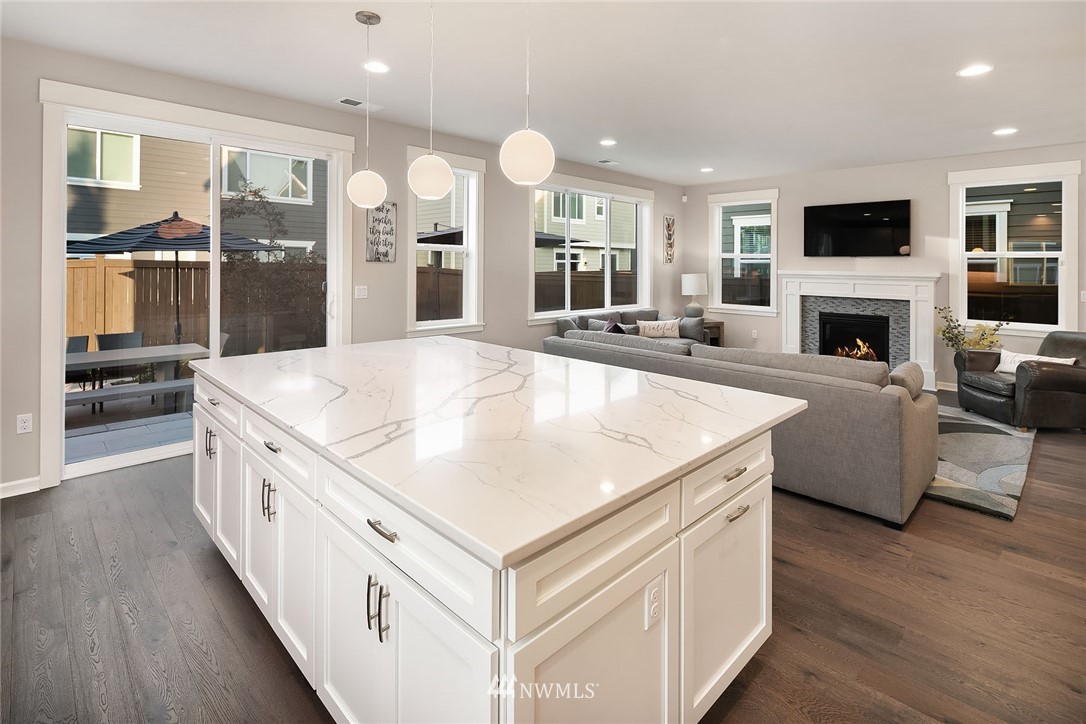 18607 45th Avenue Southeast Bothell, WA 98012 - Photo 7 of 23 a large white kitchen with a large island oven a stove and a view of living room