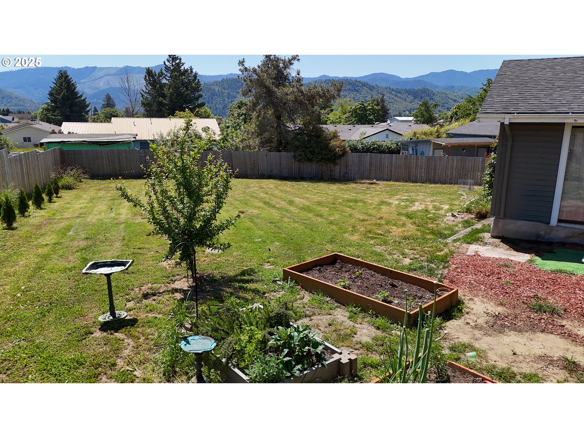 715 Penny Lane Riddle, OR 97469 - Photo 19 of 32 a backyard of a house with table and chairs