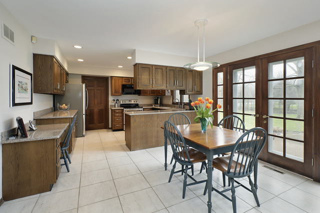 401 Voltz Road Northbrook, IL 60062 - Photo 4 of 13 a kitchen with stainless steel appliances granite countertop a stove a refrigerator a kitchen island a table and chairs