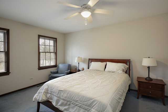 401 Voltz Road Northbrook, IL 60062 - Photo 7 of 13 a bedroom with a bed and a chandelier