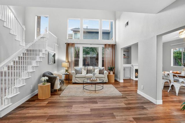 a living room with furniture a wooden floor and next to a window