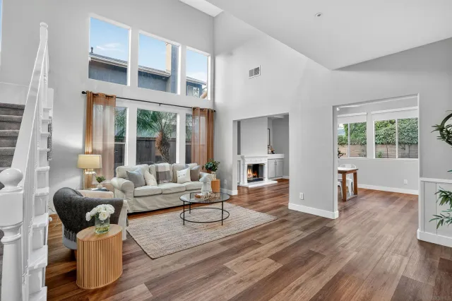 a living room with furniture large window and wooden floor