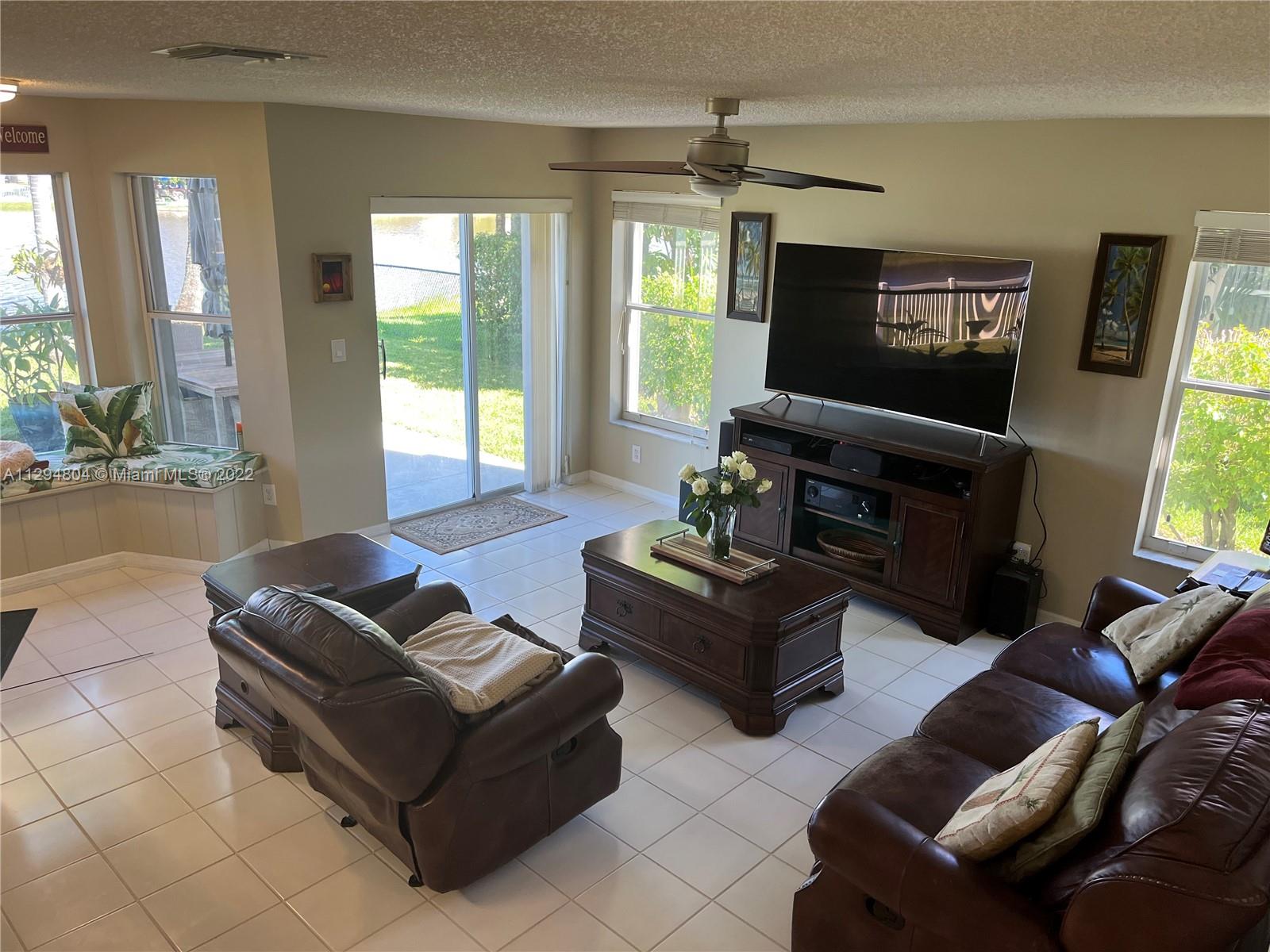 18249 Southwest 3rd Street Pembroke Pines, FL 33029 - Photo 40 of 40 a living room with furniture and a flat screen tv