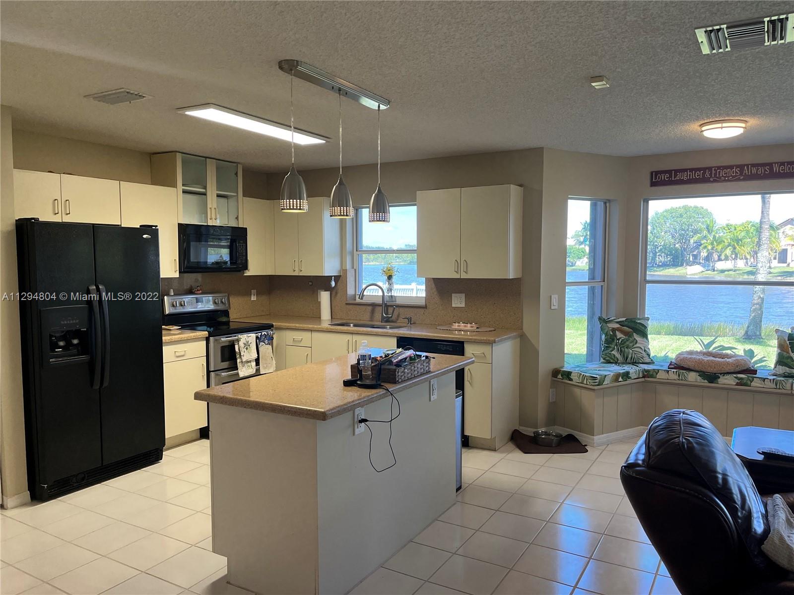 18249 Southwest 3rd Street Pembroke Pines, FL 33029 - Photo 8 of 40 a kitchen with a refrigerator and a stove top oven