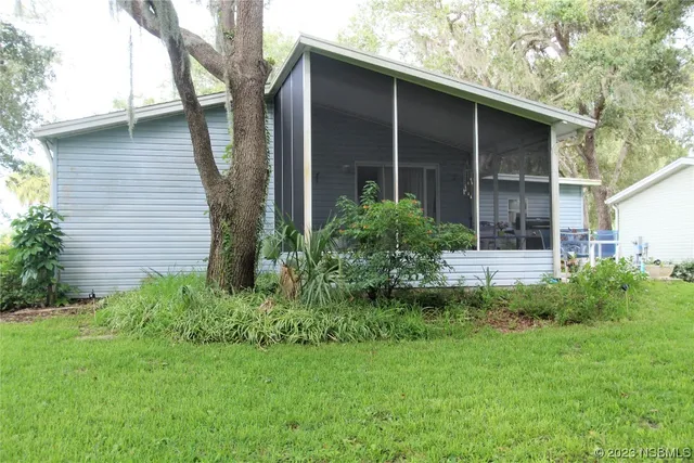 a front view of a house with a garden and tree