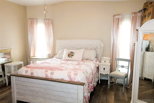 a bedroom with a bed and a mirror on the dresser