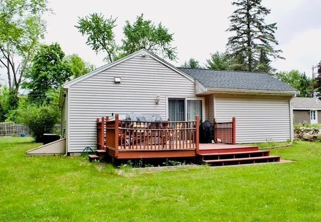 a view of a house with a yard and deck