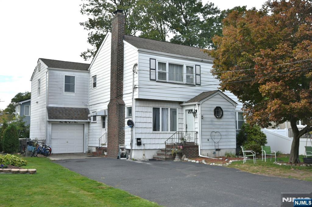 105 Parkway Rochelle Park, NJ 07662 - Photo 1 of 22 a front view of a house with a garden and trees