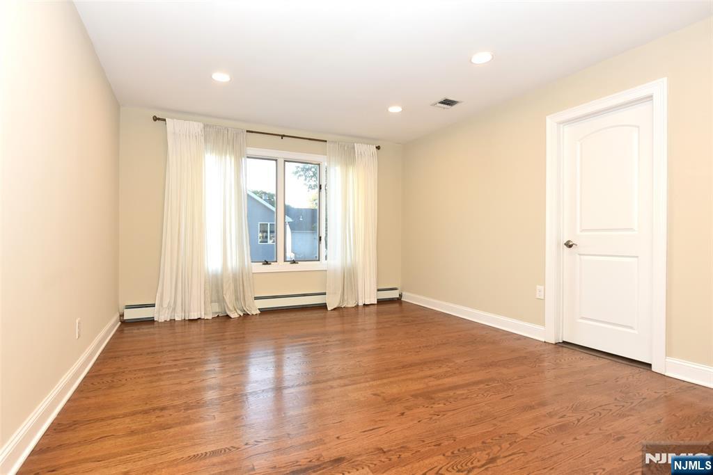 105 Parkway Rochelle Park, NJ 07662 - Photo 16 of 22 an empty room with wooden floor and windows