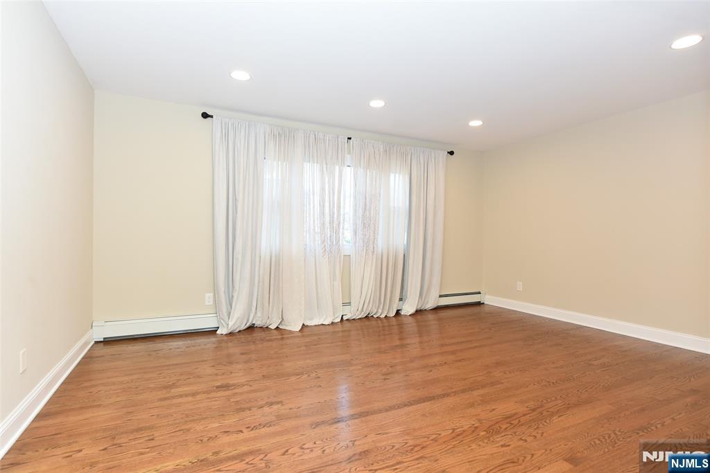 105 Parkway Rochelle Park, NJ 07662 - Photo 3 of 22 an empty room with wooden floor and window