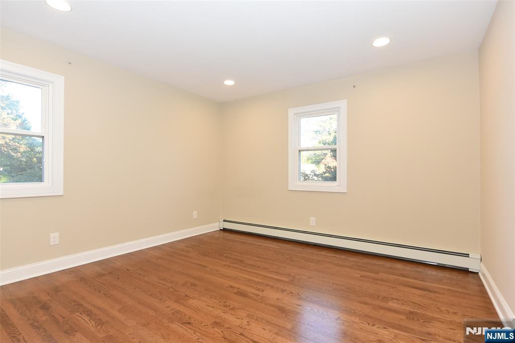 105 Parkway Rochelle Park, NJ 07662 - Photo 7 of 22 an empty room with wooden floor and windows