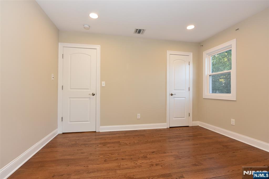 105 Parkway Rochelle Park, NJ 07662 - Photo 8 of 22 an empty room with wooden floor and windows