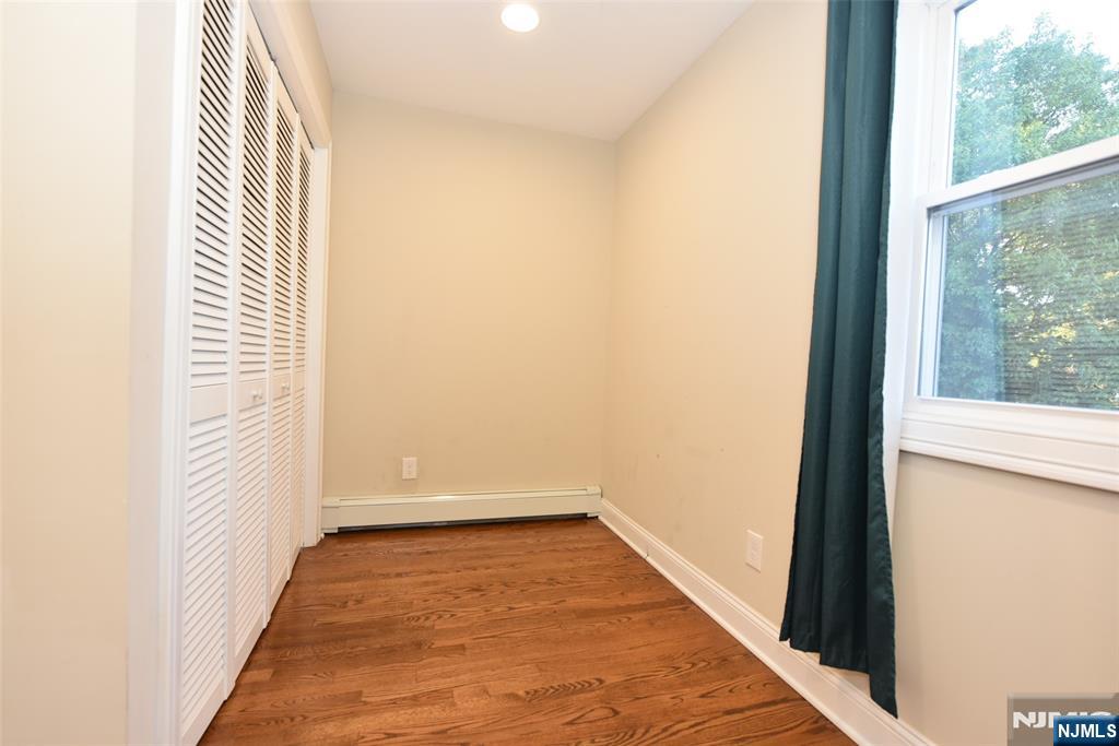 105 Parkway Rochelle Park, NJ 07662 - Photo 10 of 22 an empty room with wooden floor and windows