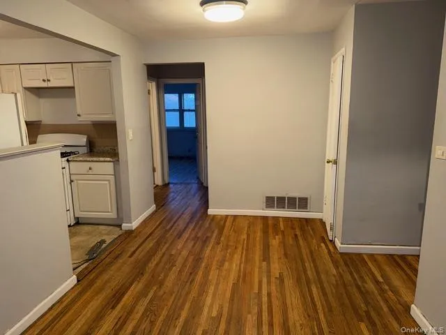 a view of a kitchen with wooden floor electronic appliances and furniture