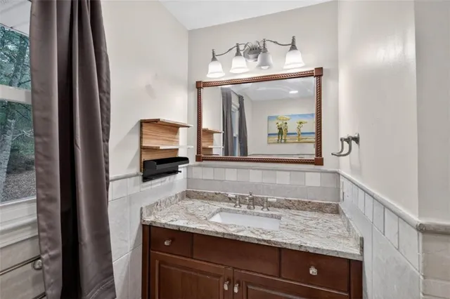 a bathroom with a granite countertop sink and a mirror