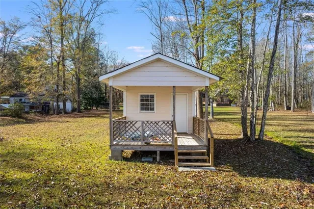 a view of a house with backyard and trees