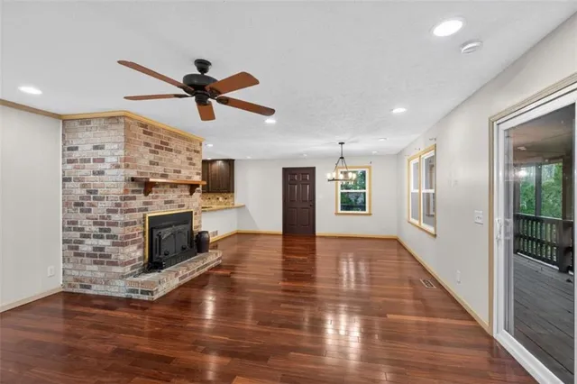 a view of a livingroom with a fireplace a ceiling fan and fire place