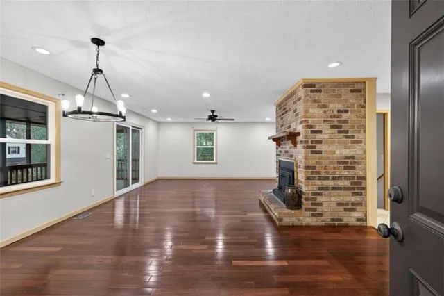 a view of empty room with wooden floor and windows