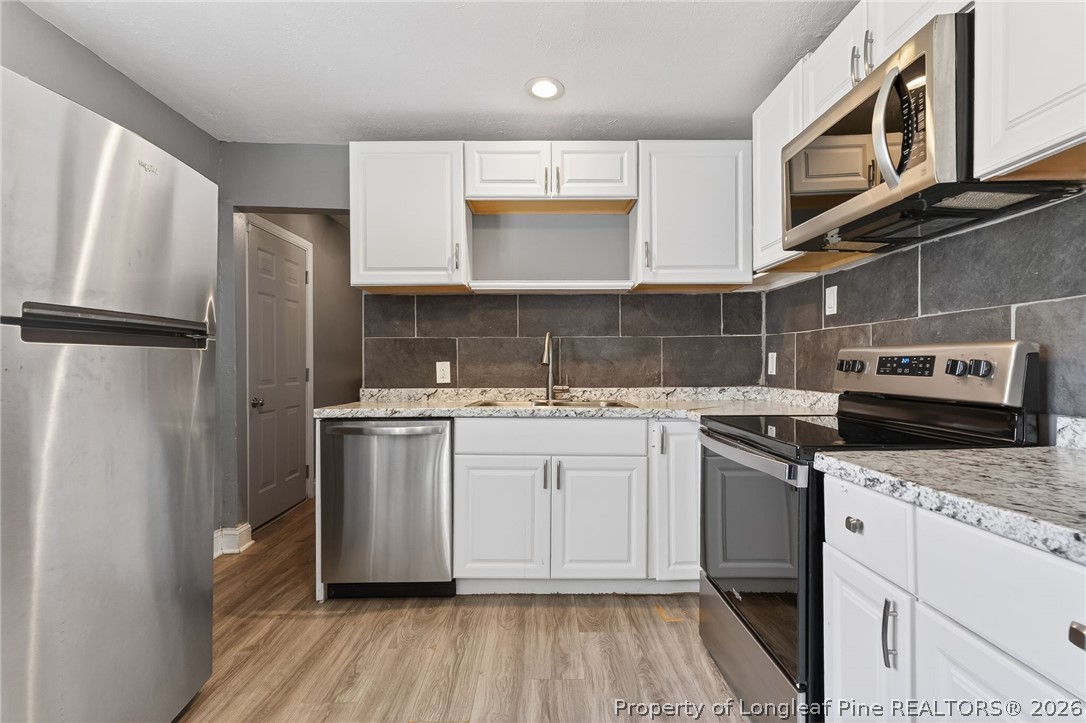 1586 Tom Starling Road Fayetteville, NC 28306 - Photo 12 of 44 a kitchen with stainless steel appliances granite countertop a refrigerator sink and stove