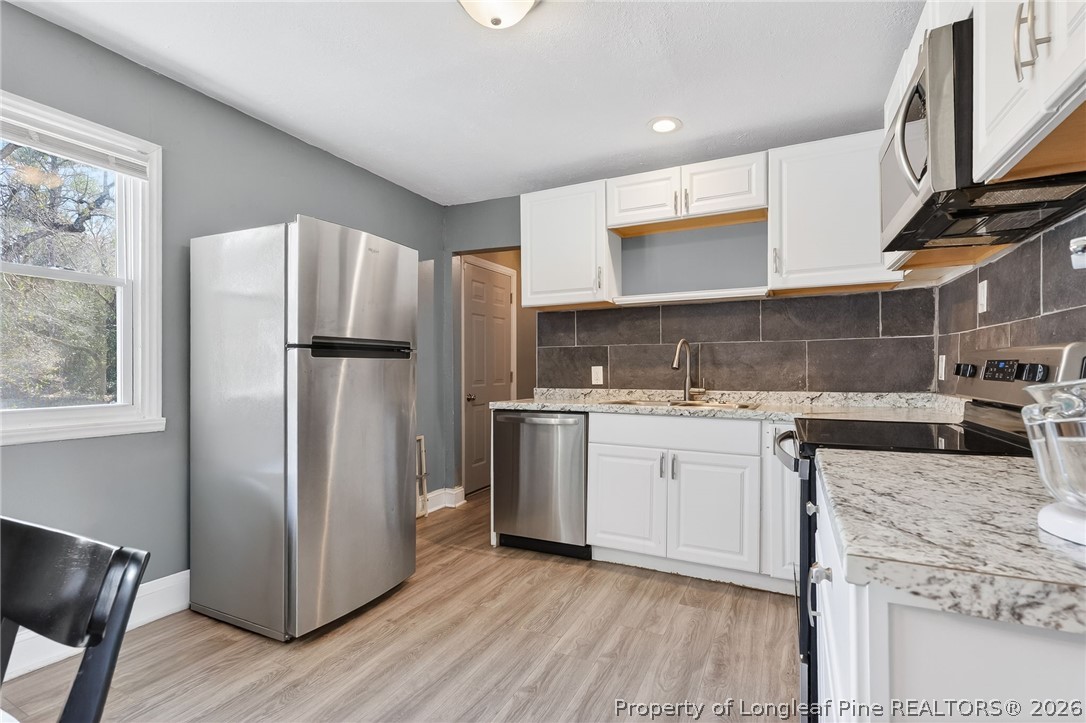 1586 Tom Starling Road Fayetteville, NC 28306 - Photo 13 of 44 a kitchen with a refrigerator sink and cabinets