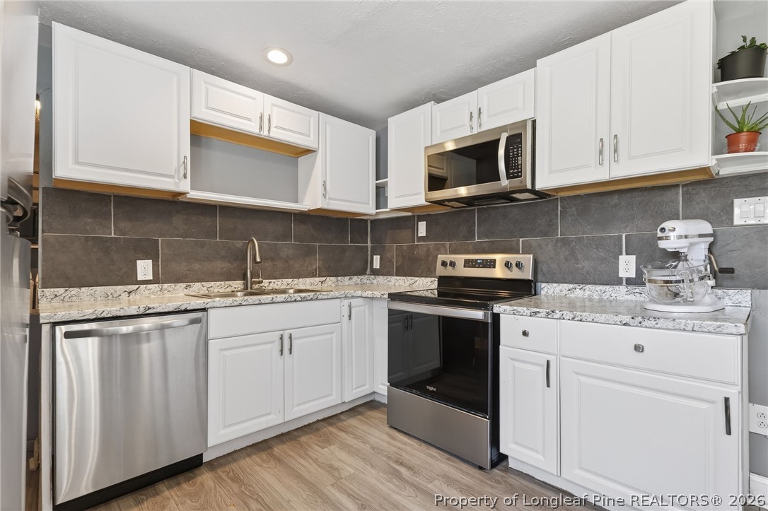 1586 Tom Starling Road Fayetteville, NC 28306 - Photo 14 of 44 a kitchen with stainless steel appliances granite countertop a sink and a stove