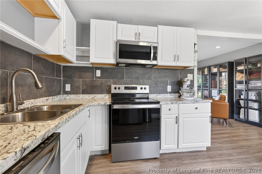 1586 Tom Starling Road Fayetteville, NC 28306 - Photo 15 of 44 a kitchen with stainless steel appliances granite countertop a sink and a stove