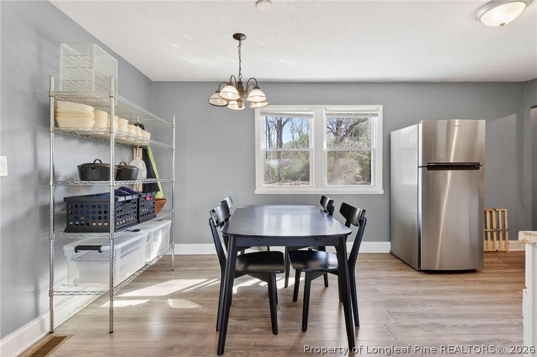 1586 Tom Starling Road Fayetteville, NC 28306 - Photo 10 of 44 a view of a dining room with furniture a chandelier and wooden floor
