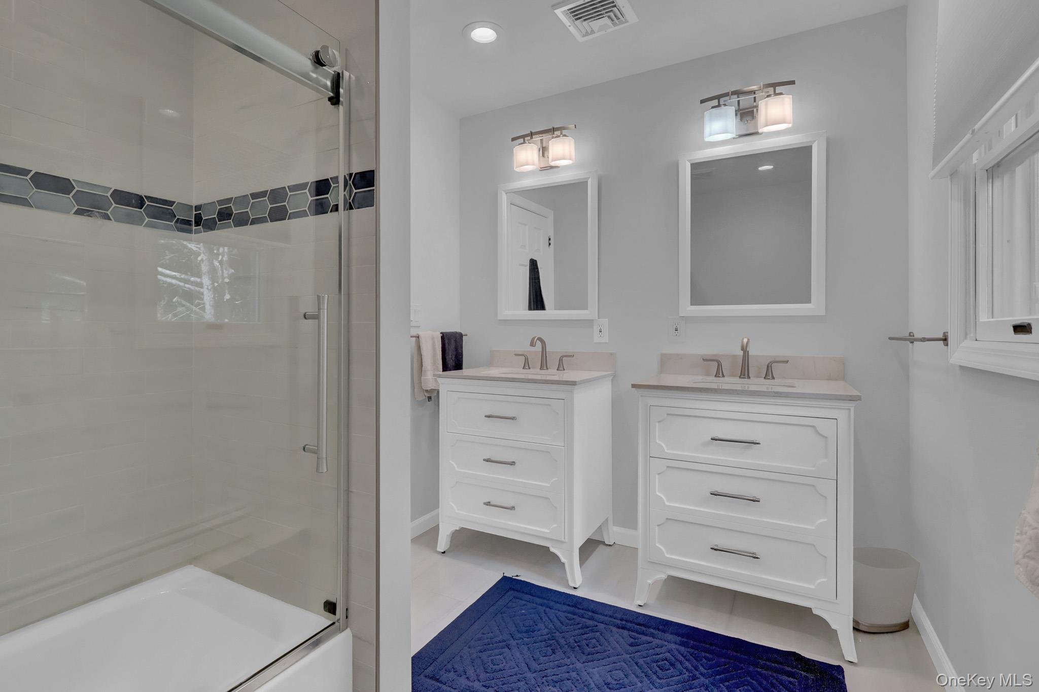 15 Stillwater Road Nissequogue, NY 11780 - Photo 28 of 43 Bathroom featuring a glass-enclosed tub/shower combo with a decorative hexagonal tile accent
