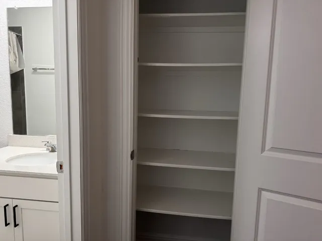 a view of walk in closet with empty racks