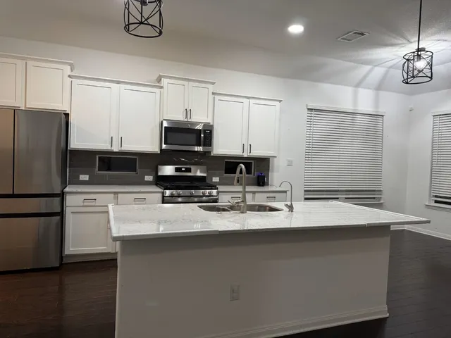 a kitchen with stainless steel appliances a stove refrigerator sink and microwave