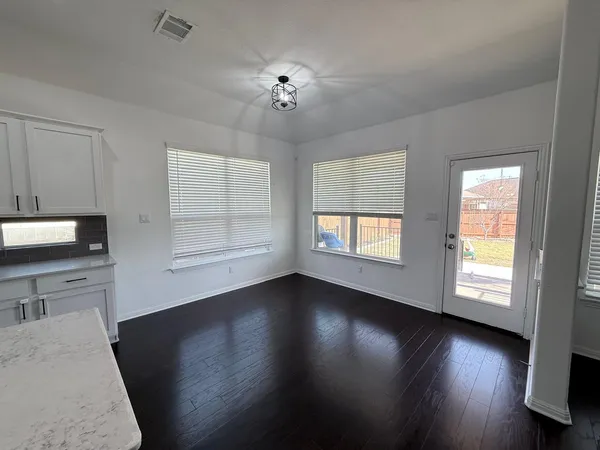 a view of empty room with wooden floor and fireplace