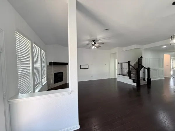 a view of a livingroom with wooden floor and a ceiling fan