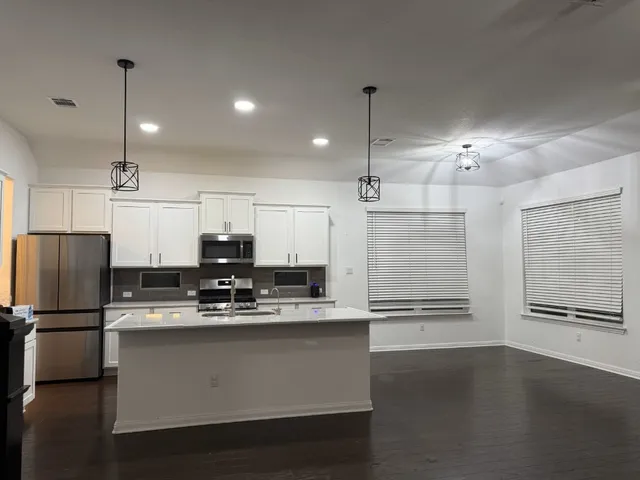 a kitchen with kitchen island stainless steel appliances a refrigerator sink and cabinets