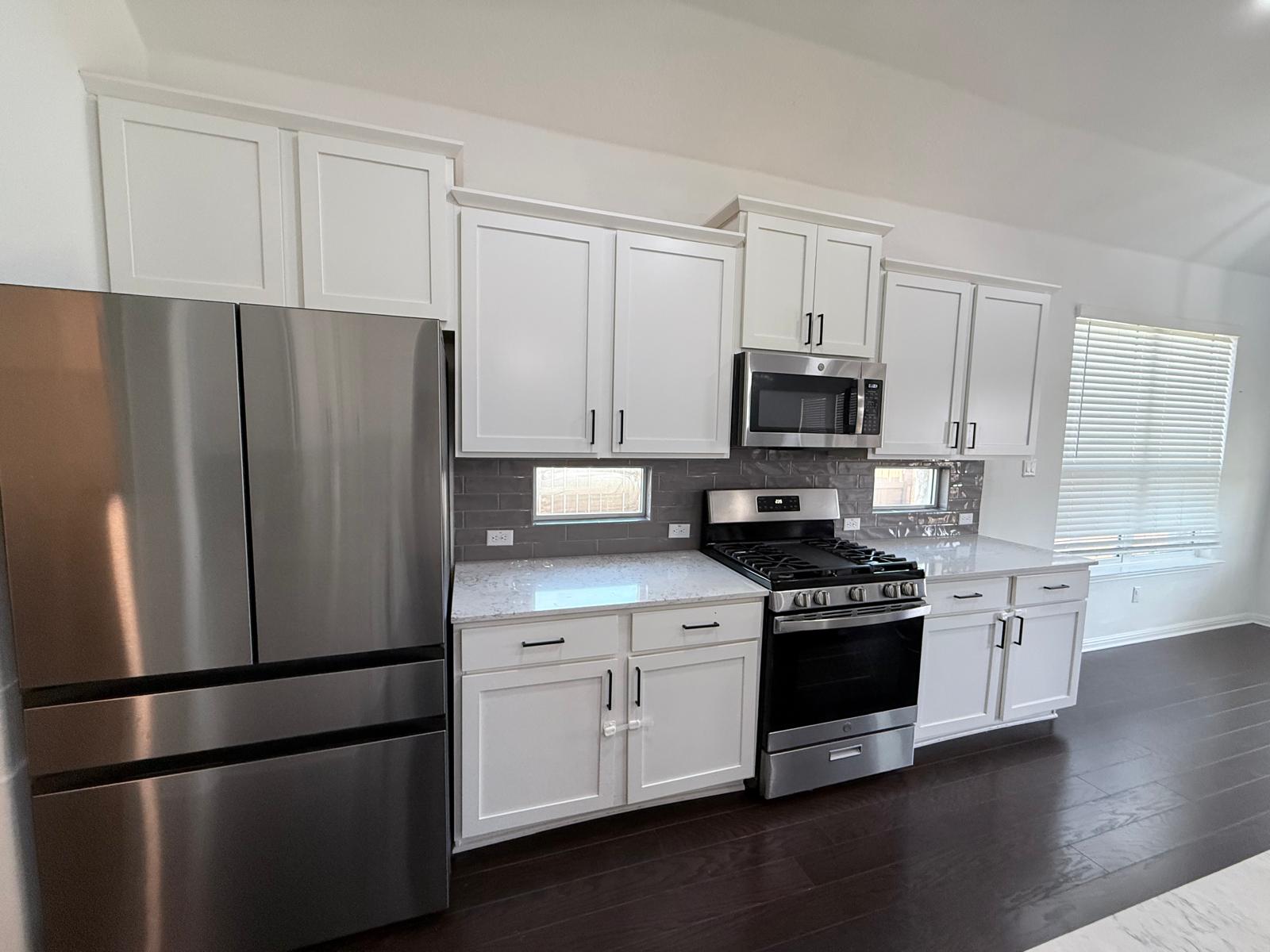 160 Venti Cove Georgetown, TX 78628 - Photo 31 of 40 a kitchen with stainless steel appliances and wooden cabinets