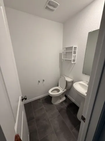 a white toilet sitting next to a shower