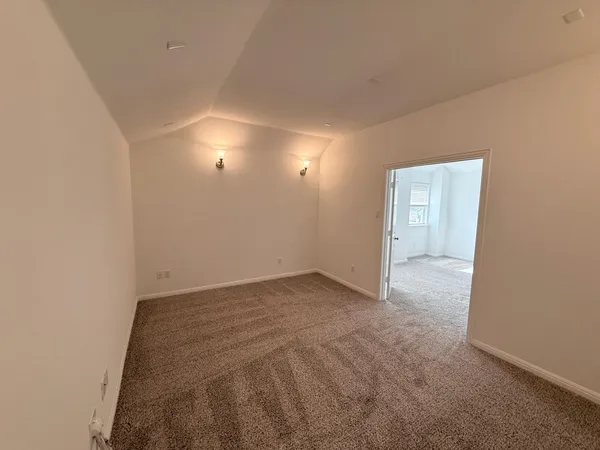 an empty room with a ceiling fan and wooden floor