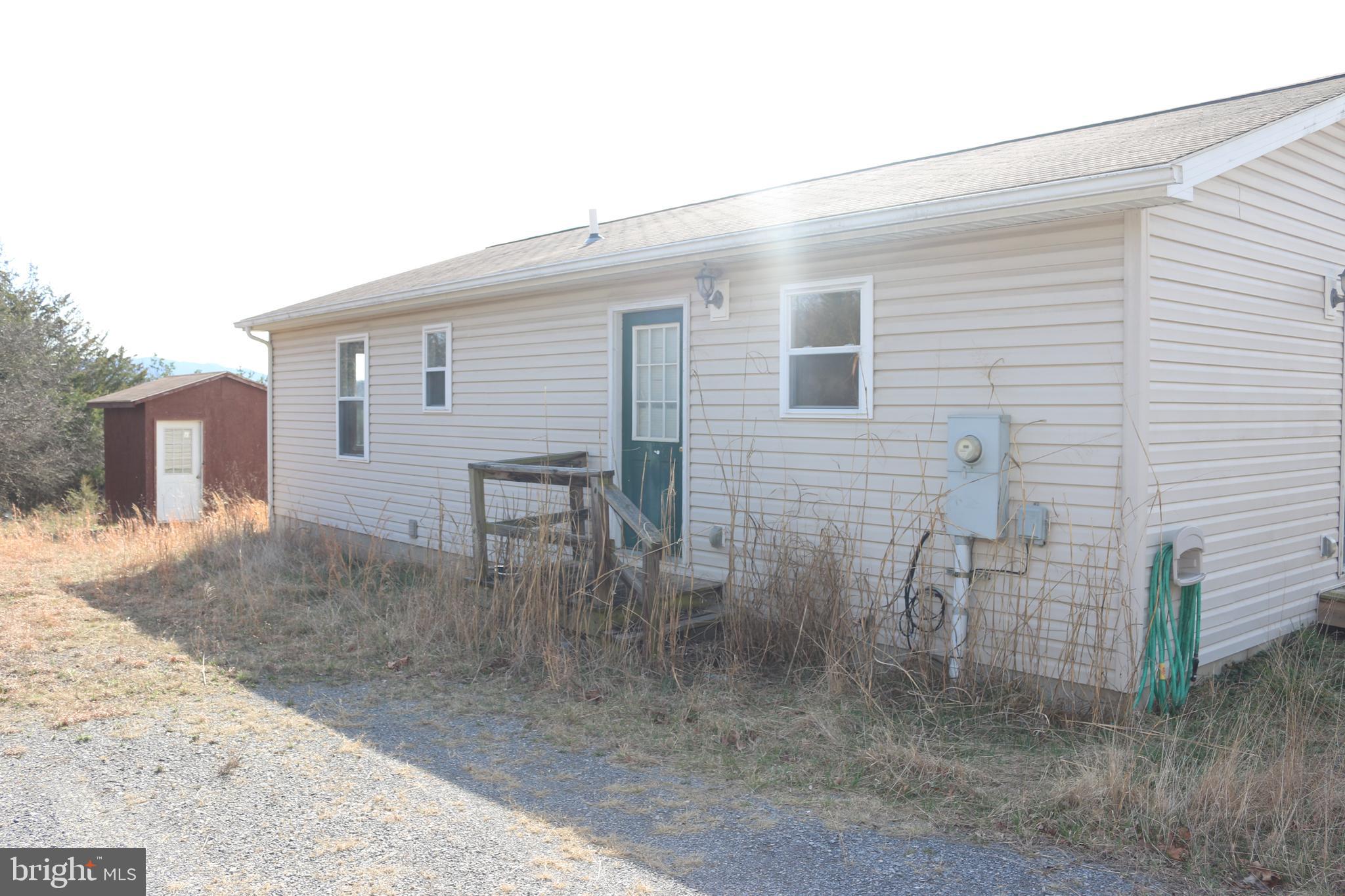 156 Squirrel Den Road Maysville, WV 26833 - Photo 12 of 41 a backyard of a house with table and chairs