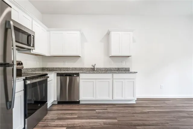 a kitchen with stainless steel appliances granite countertop a stove a sink and a microwave