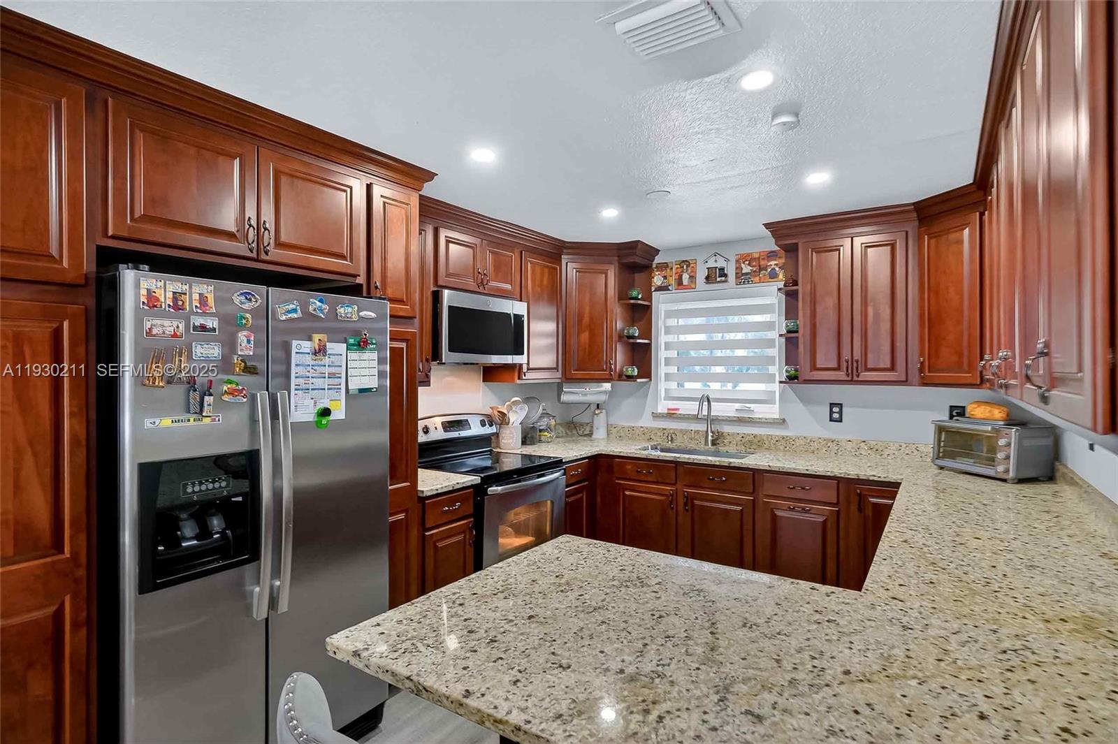 20810 Southwest 125th Court Road Miami, FL 33177 - Photo 15 of 52 a kitchen with stainless steel appliances granite countertop a sink stove and refrigerator
