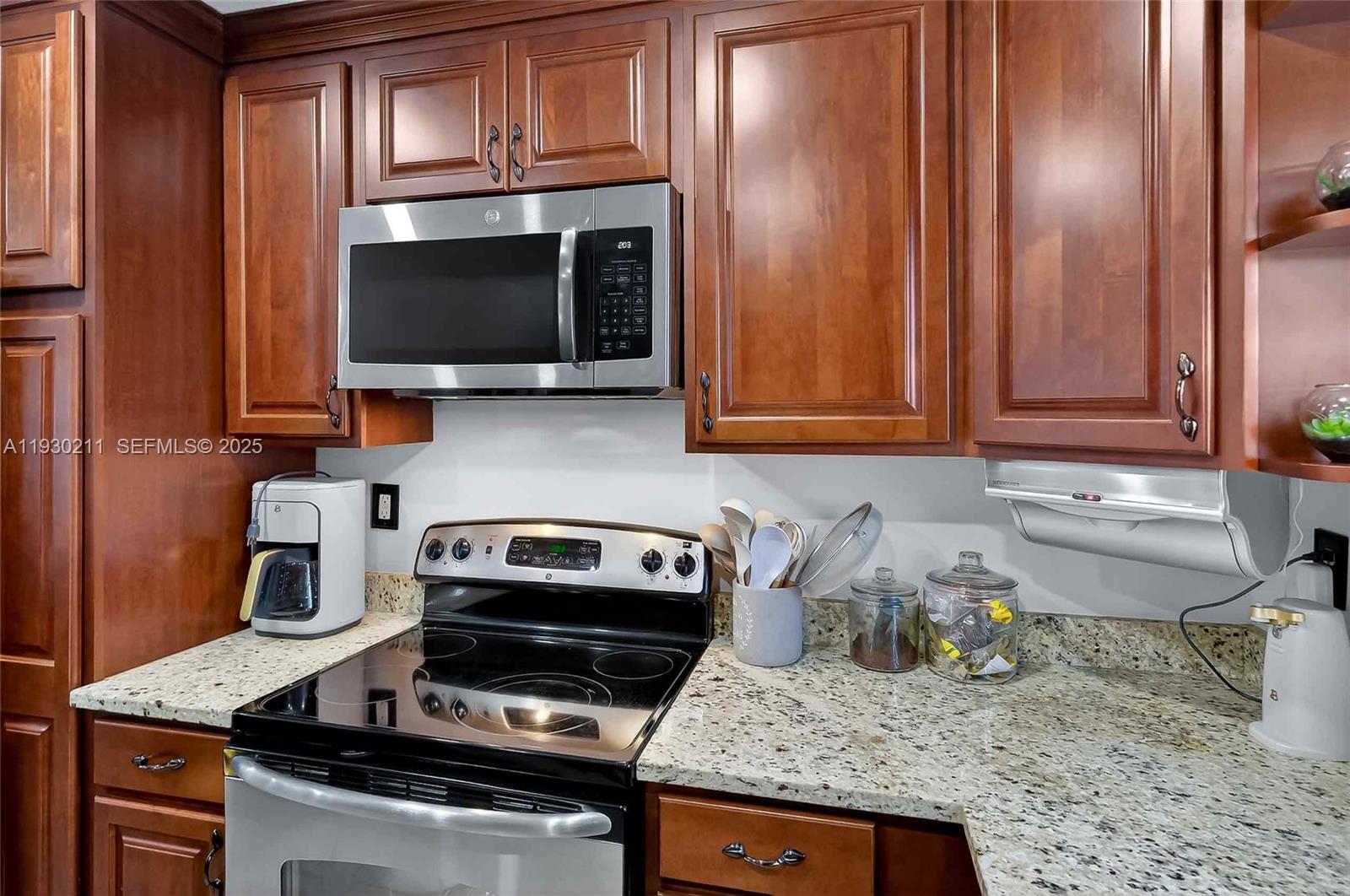 20810 Southwest 125th Court Road Miami, FL 33177 - Photo 19 of 52 a kitchen with a stove and a microwave