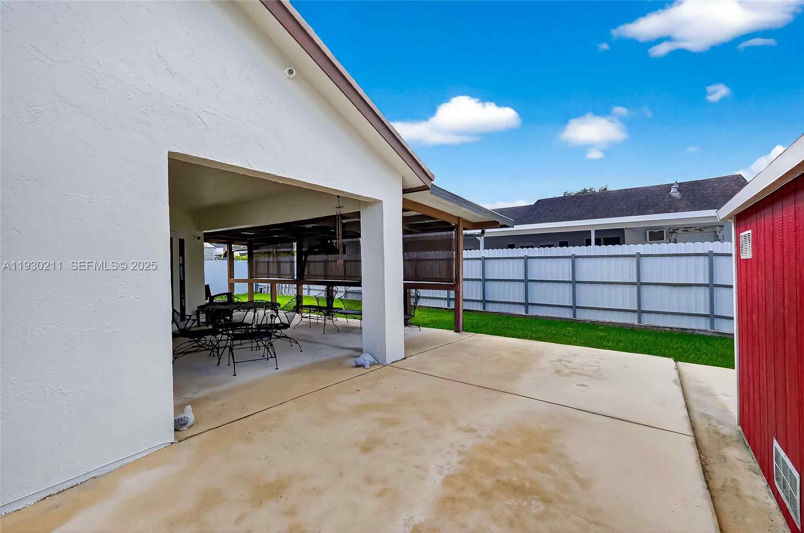 20810 Southwest 125th Court Road Miami, FL 33177 - Photo 42 of 52 a view of a patio with a table and chairs under an umbrella next to a yard