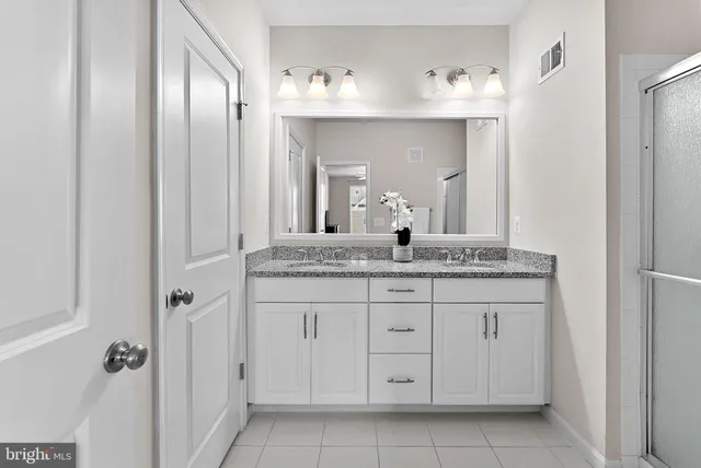 a bathroom with a granite countertop sink a mirror and a vanity