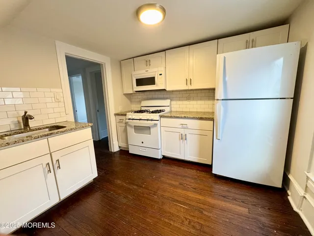 a kitchen with white cabinets and white appliances