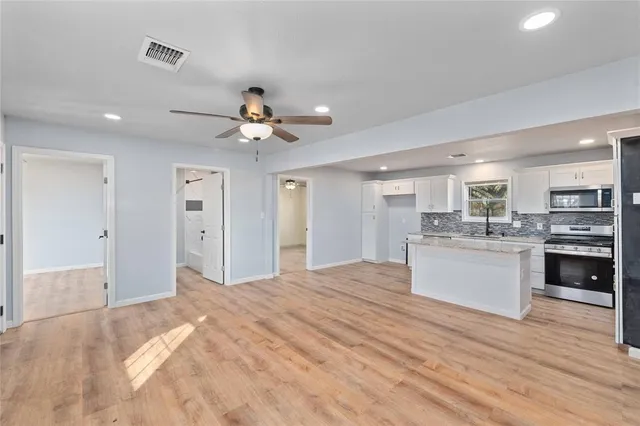 a open kitchen with white cabinets and stainless steel appliances