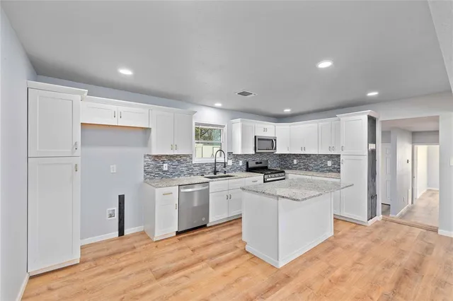 a kitchen with a sink and white cabinets