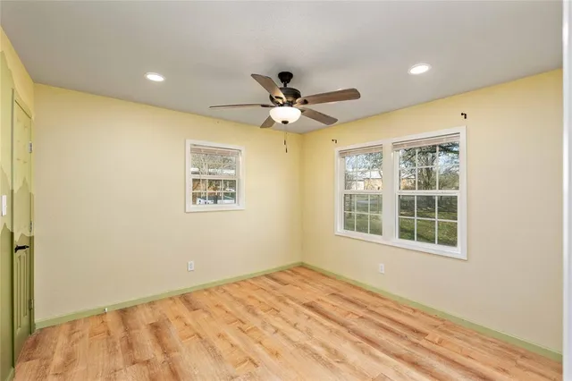 a view of a big room with wooden floor and windows