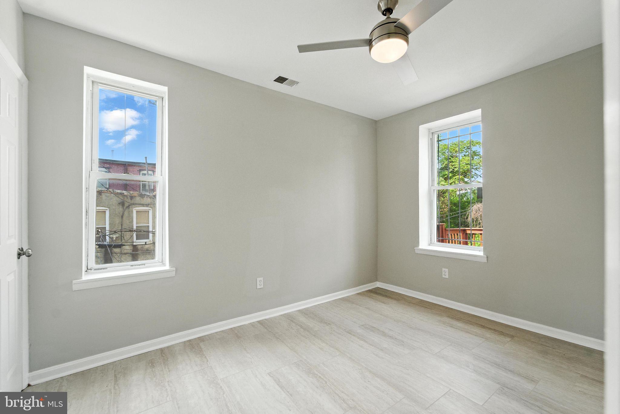 2100 Homewood Avenue, Unit 2 Baltimore, MD 21218 - Photo 2 of 10 a view of an empty room with a window and wooden floor