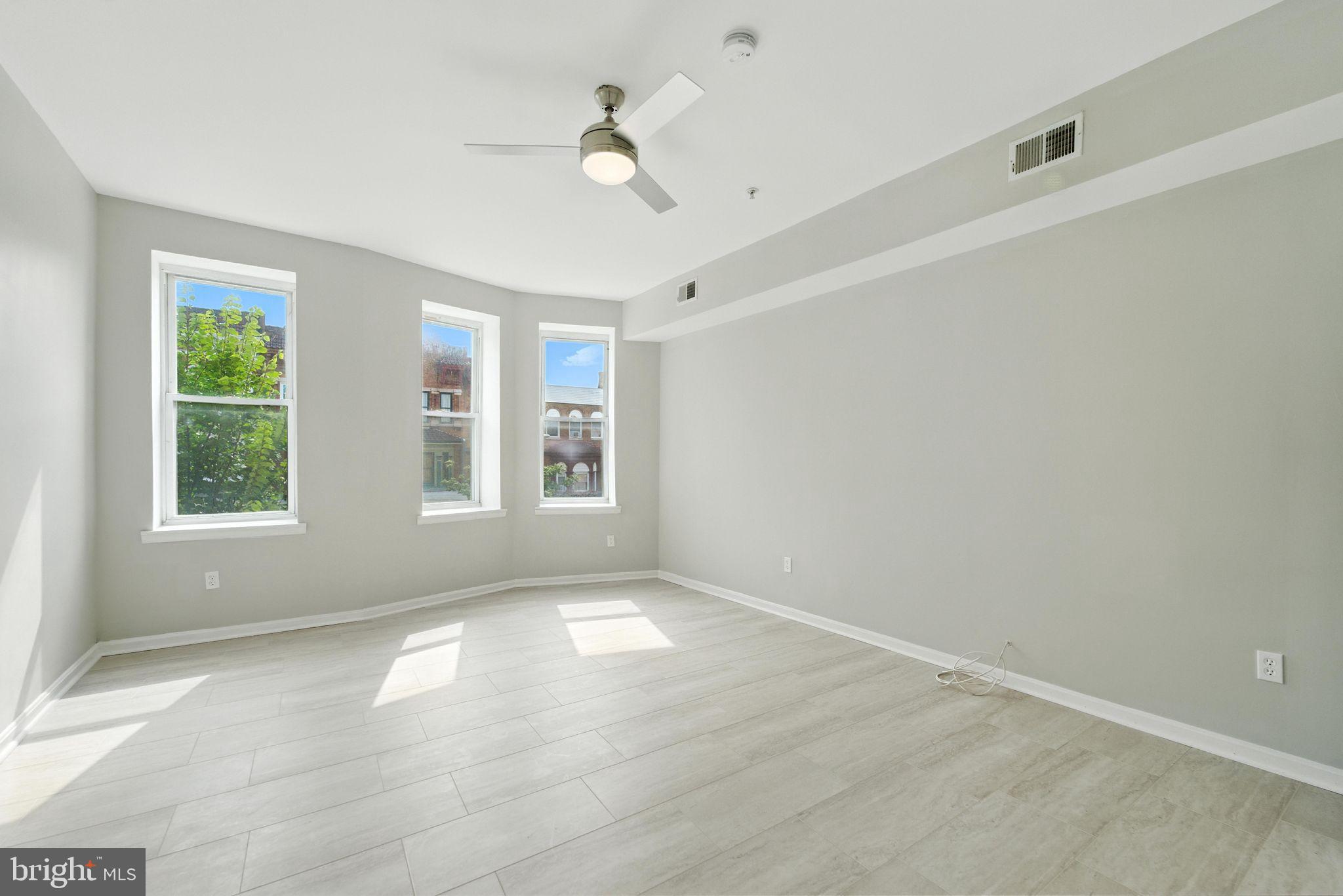 2100 Homewood Avenue, Unit 2 Baltimore, MD 21218 - Photo 3 of 10 an empty room with windows and ceiling fan